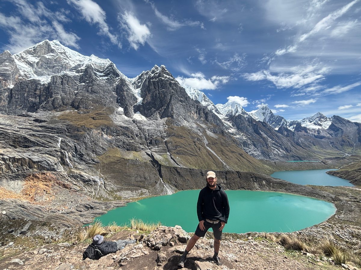 Simon Lusignan overlooking a turquoise glacial lake in the Cordillera Huayhuash, the kind of high-stakes trail you're training for